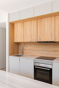 带木制家具、灰色台面和内置电器的现代厨房采用简约的室内设计