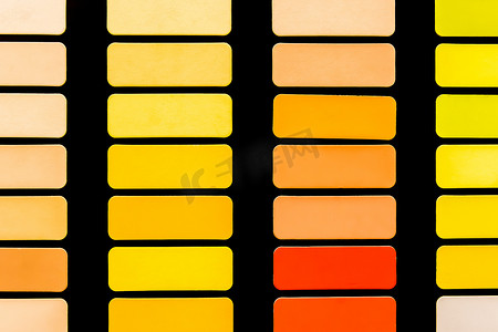 抽象色彩鲜艳背景摄影照片_黑色背景中正方形中不同色调的红色、黄色和橙色样本，色彩鲜艳的抽象马赛克纹理