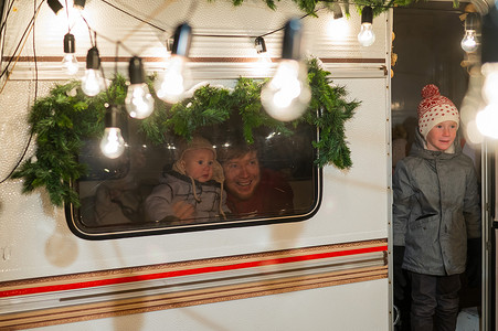 儿童拖车摄影照片_父亲和两个儿子在面包车里庆祝圣诞节。