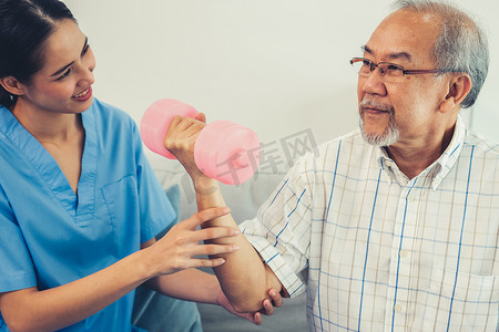 在护理人员的帮助下进行物理治疗的心满意足的老年患者。