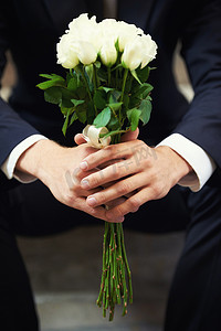鲜花的男人摄影照片_手、鲜花和男人在婚礼当天等待爱情、传统或浪漫特写的仪式。