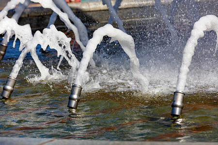 出水素果摄影照片_城市花岗岩喷泉中的金属大炮喷出浓稠的泡沫状水流。