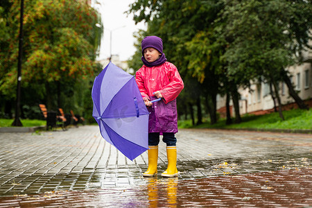 孩子在秋雨中玩耍。