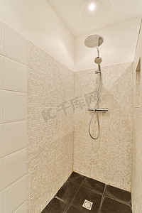 澡堂浴帘摄影照片_带淋浴喷头的白色瓷砖淋浴间