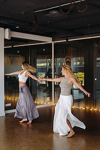 运动妇女摄影照片_运动服的两名妇女在健身房做舞蹈瑜伽