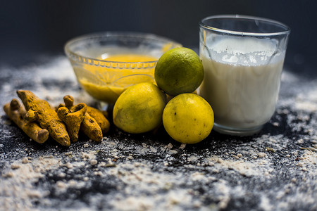 克力摄影照片_木质表面上的柠檬面罩，由柠檬汁、克面粉或鹰嘴豆粉、姜黄或 Haldi 和玻璃碗中的牛奶组成。用于治疗晒黑。
