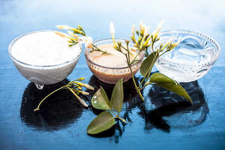 印度茉莉 Ayurevidic 面膜在木质表面的玻璃碗中，即茉莉花瓣与牛奶奶油和水充分混合。