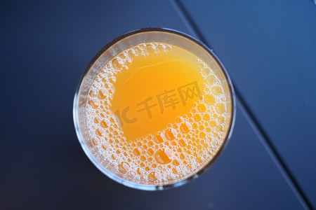 桌上有气泡的一杯橙汁的顶视图