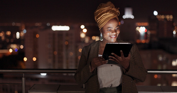平板电脑、夜晚和阳台，一位商务黑人女性站在办公室户外进行在线研究。