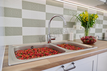 草莓季节，在家庭厨房的洗脸盆里用水洗浆果