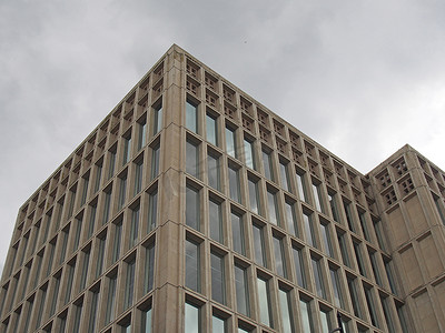 1960 年代典型野兽派风格混凝土办公楼的角落细节，在灰色多云的天空中采用几何混凝土框架