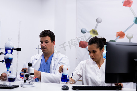 化学实验室穿着摄影照片_在研究实验室穿着外套的研究人员团队