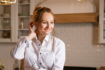 厨房里一位身穿白衬衫的年轻女子的画像