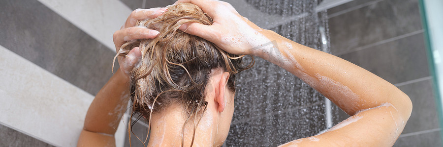 年轻女人用洗发水洗头，手用泡沫特写