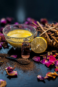 粉利摄影照片_黑色木质表面上的 manjistha 或 Indin 茜草根面罩，由 manjistha 根粉、柠檬、牛奶和一些必需的玫瑰油组成。
