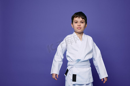 迷人自信的合气道摔跤手 — 身穿白色和服的白人少年，在紫色背景中被隔离，带有复制广告空间。