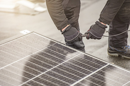 太阳能电池板安装人员使用电缆或插头线将模块连接在一起。
