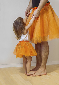 父亲和小女孩穿着芭蕾舞裙跳舞