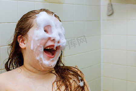 美女浴缸洗澡摄影照片_快乐的小美女脸在浴室里游泳
