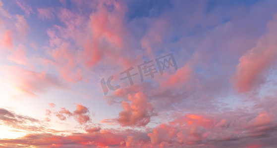 五颜六色的橙紫色戏剧性的云被落日照亮，映衬着傍晚的天空。