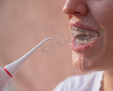 一位戴牙套的女士使用冲洗器。