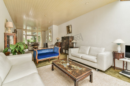 舒适的沙发，靠垫靠在轻质墙壁上，配有电视和装饰，位于带天井门的现代爱室