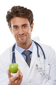 If you want to keep me away.....Studio portrait of a young doctor holding a apple up to the camera.