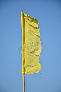 竹竿黄色摄影照片_沙滩上放着竹竿的黄旗布