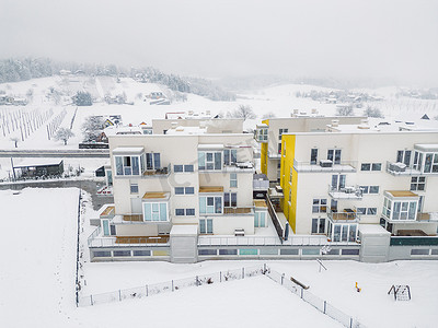 斯洛文尼亚白雪皑皑的乡村中新现代公寓大楼的鸟瞰图