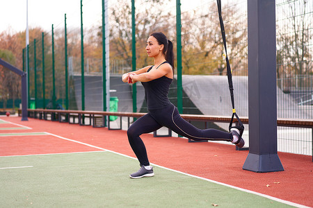 在运动场上使用 trx 进行女运动员训练。