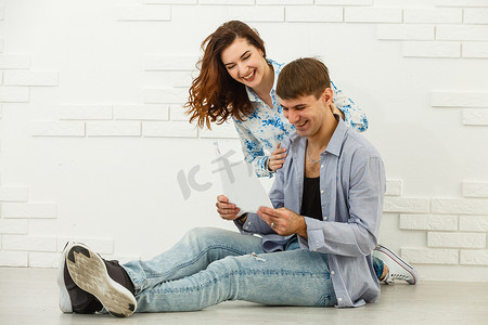 微笑的夫妻坐着处理水电费和房屋维修文件，快乐的年轻夫妇阅读文书工作