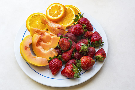 盘子里的草莓、木瓜片和橙片，顶部 vi