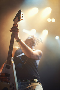 一闪一闪的灯摄影照片_一位吉他手在频闪灯下尽情演奏。