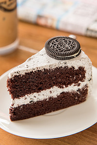 奥利奥可可摄影照片_奥利奥巧克力蛋糕和白色盘子上的生奶油和窝