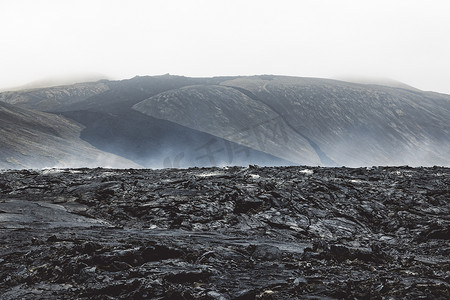 灰尘的旅行摄影照片_仍然炽热的熔岩岩石和从炽热地面升起的蒸汽的壮观景色