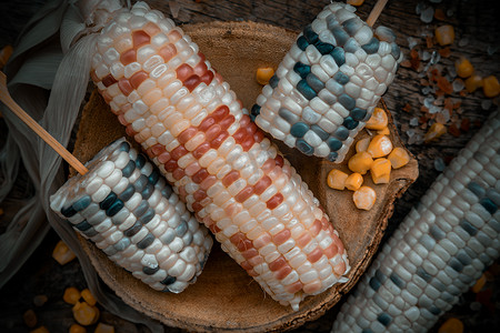 玉米粒摄影照片_新鲜糯玉米或甜糯玉米和玉米仁在质朴的旧木背景上的特写镜头。