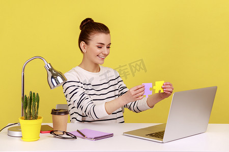 工作难题摄影照片_向笔记本电脑展示的女性展示了两块彩色拼图，轻松解决了工作中的难题