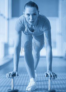 年轻健身女性在健身房用哑铃锻炼，运动理念