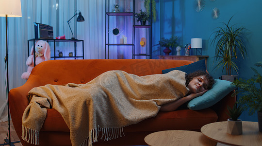 在家休息摄影照片_疲惫的黑发年轻女人躺在床上在家休息，在沙发上打瞌睡