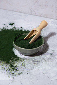 功能食品摄影照片_蓝绿藻小球藻和螺旋藻粉用木勺放在碗里。