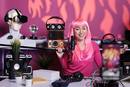 站在广播工作室时，快乐的女性使用专业的流媒体设备录制播客
