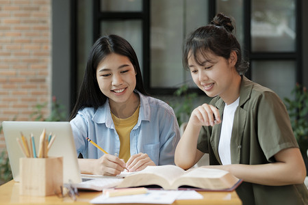 年轻的亚洲学生校园帮助朋友赶上和学习。