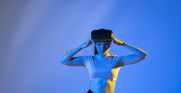 中元节特惠摄影照片_年轻女子戴着虚拟现实护目镜，在元宇宙中与朋友聊天。