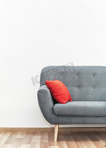 现代灰色沙发，在木瓷砖地板上配有红色枕头 — 办公家具、白墙 — 文字空间 — 以上
