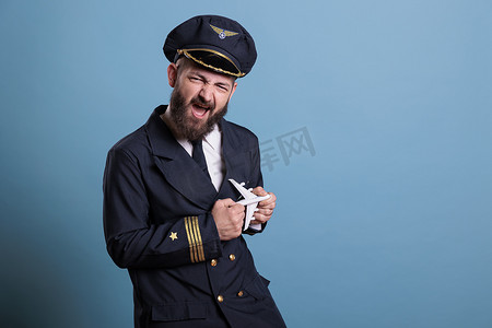 穿着制服的滑稽飞行员玩小飞机模型