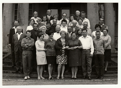 复古照片显示一群人在建筑物前，大约 1970 年代。