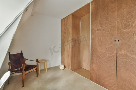 一间带椅子和木制壁橱的小房间