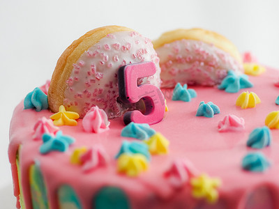 白色背景上粉红色的 5 周年生日磨砂糖霜滴蛋糕