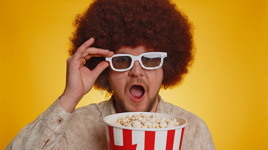 电影视频片摄影照片_兴奋的男人吃爆米花，看有趣的电视连续剧、体育游戏在线社交媒体电影
