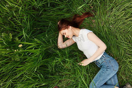 平静、平和的女人在高高的草丛中睡着了